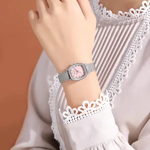 Detail shot of a silver square watch with a pink dial on a woman's wrist