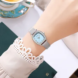 Detail of elegant silver mesh strap and light blue square dial with crystal markers