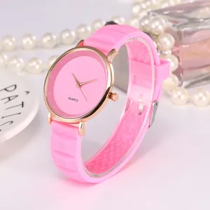 Détail de la montre femme en silicone rose avec boîtier en or rose sur fond élégant
