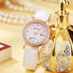 Détail macro d'une montre à quartz or rose avec strass et bracelet en cuir blanc