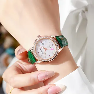 Gros plan d'une montre or rose avec cadran en nacre et bracelet en cuir vert élégant