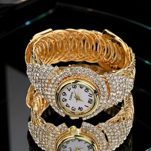 Macro shot of gold quartz watch with rhinestones reflecting on a black surface