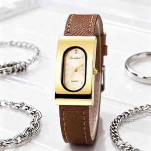 Macro shot of vintage rectangular gold watch with brown leather strap and jewelry details