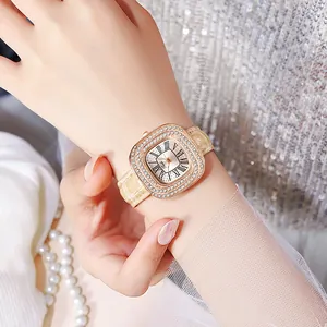 Détail d'une montre carrée élégante en or rose avec strass et bracelet en cuir beige
