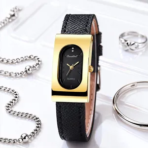 Detail of vintage rectangular gold watch with black oval dial and leather strap