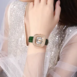 Gros plan d'une montre carrée or rose avec lunette en cristal et bracelet cuir vert