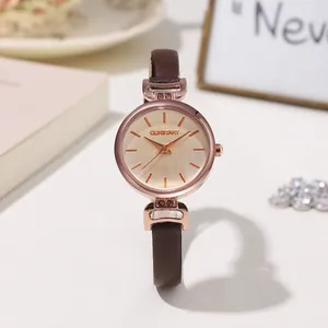 Dettaglio di un orologio da donna in oro rosa con cinturino in pelle marrone e quadrante