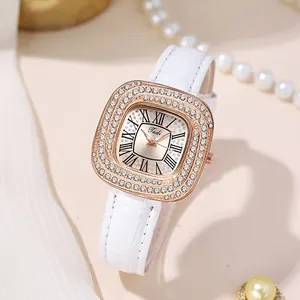 Détail d'une montre carrée en or rose avec zircons et bracelet en cuir blanc gaufré