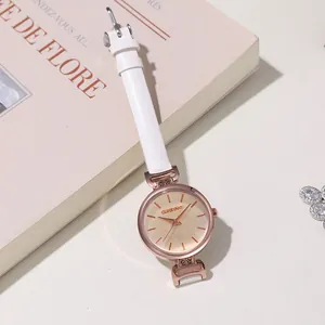 Dettaglio orologio da donna oro rosa con cinturino bianco e decorazioni in cristallo