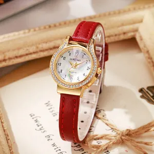 Detail of rose gold watch with sparkling bezel and red leather strap on vintage background