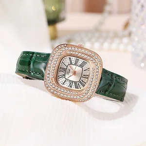 Détail de montre en or rose avec bracelet en cuir vert et lunette sertie de strass