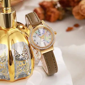 Close-up of gold lady watch with colorful pearl dial and diamond-set bezel on leather strap