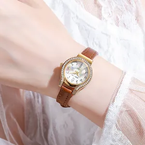 Detail of OURSTART watch with crystal bezel, rainbow mop dial, and brown leather strap