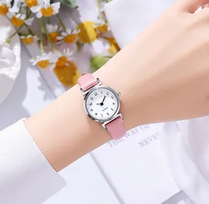 Primer plano de reloj de cuarzo con correa de cuero rosa y esfera blanca