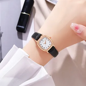 Nahaufnahme einer Vintage-Quarzuhr in Roségold mit schwarzem Lederarmband am Handgelenk