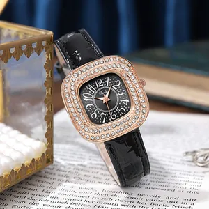 Close-up of square rose gold watch with crystal bezel and black leather strap