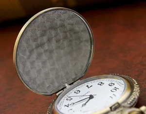 Macro detail of antique bronze pocket watch with zodiac engravings and quartz dial