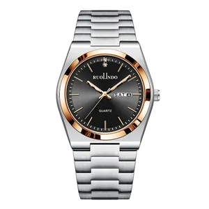 Detail of luminous quartz watch face with day-date window and two-tone steel strap