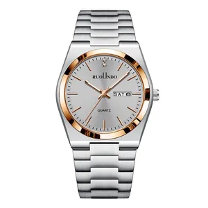 Close-up of silver and rose gold steel watch dial with day-date display and markers