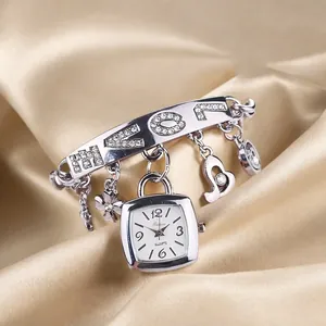 Détail de la montre bracelet à breloques LOVE argentée et strass sur soie