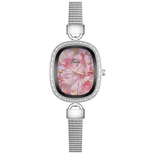 Detail of silver mesh band watch with pink marble dial and rhinestone bezel
