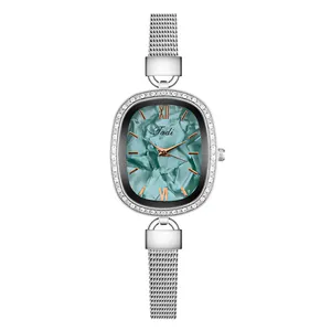 Detailed macro view of an oval turquoise dial watch with a silver mesh strap and crystal bezel