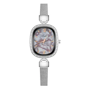 Detail of silver mesh band watch with rhinestone oval case and marble textured dial