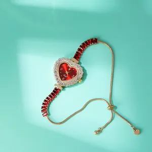 Dettaglio orologio a cuore rosso con lunetta in zirconi e bracciale a catena dorata