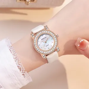 Detail of rose gold watch with baguette-cut rhinestones and white mother of pearl dial