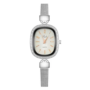 Detail of silver oval quartz watch with rhinestone bezel and stainless steel mesh strap