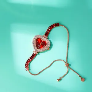 Dettaglio orologio a cuore con quadrante sfumato rosso e cinturino a scorrimento rosa