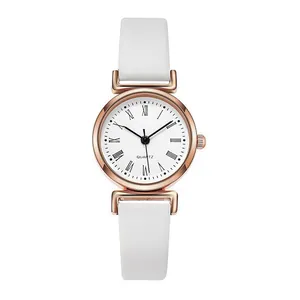 Gros plan du cadran blanc élégant d'une montre à quartz avec boîtier doré rose et chiffres romains