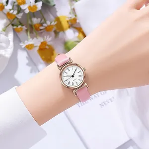 Montre élégante pour femme avec bracelet en cuir rose et chiffres romains au poignet