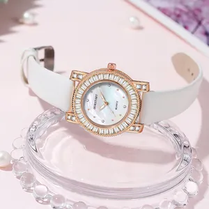 Detailed close-up of a women's watch featuring a diamond-set bezel and mother of pearl dial