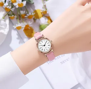 Détail du bracelet en cuir rose et cadran blanc porté avec décor de marguerites