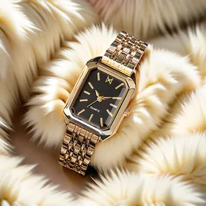 Close-up of elegant rectangular gold watch with black dial on plush white background