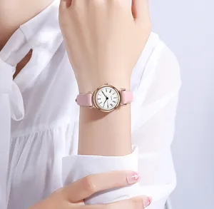 Gros plan d'une montre à quartz minimaliste pour femme avec bracelet en cuir rose et boîtier