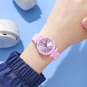 Pink quartz watch with silicone strap and diamond-cut bezel shown on wrist with headphones