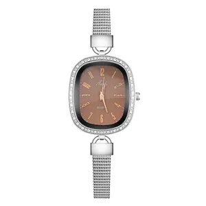 Close-up of elegant oval quartz watch with brown dial, crystal bezel and silver mesh strap