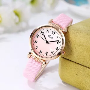 Detail of pink woven strap and gradient dial on a rose gold women's quartz watch