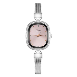 Close-up of elegant women's watch featuring a diamond-encrusted bezel and a pink shell dial