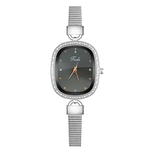 Close-up of elegant women's watch with rhinestone bezel and silver Milanese mesh strap