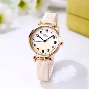 Detailed close-up of a women's quartz watch with rose gold case and beige textured strap