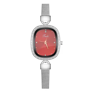 Close-up of the silver mesh strap and rhinestone-encrusted oval case on the quartz watch