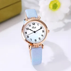 Close-up of rose gold quartz watch with gradient blue strap and clean Arabic numerals