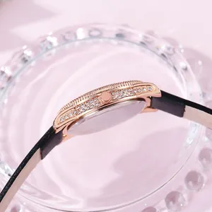 Detail of rose gold watch case with double-row crystals and black leather strap