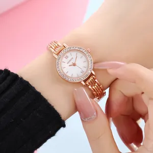 Detail of rose gold ladies watch with crystal bezel and Roman numeral white dial