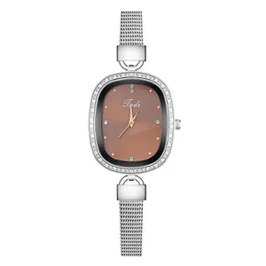 Detail of the oval brown dial with Tidi logo and sparkling zircon-set bezel on silver watch