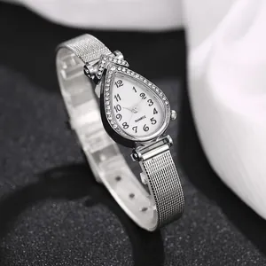 Detailed close-up of a silver teardrop watch with diamond-set bezel and mesh strap
