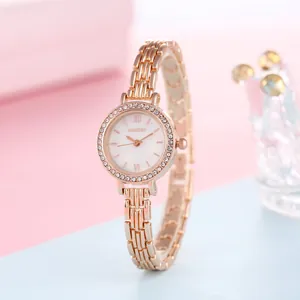 Detailed close-up of rose gold watch bezel with sparkling crystals and metal link strap